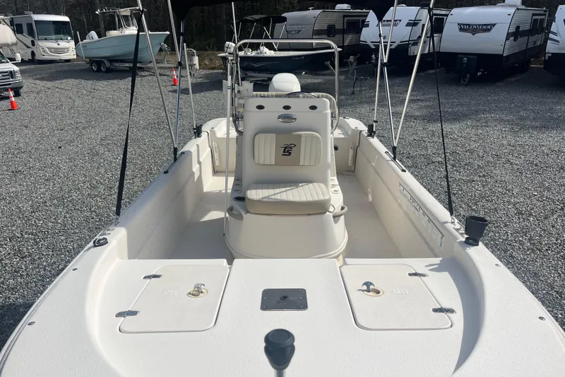 Slide: The Image of 2019 Carolina Skiff 18 JVX SS boat with seating and storage, parked on gravel lot. - 4