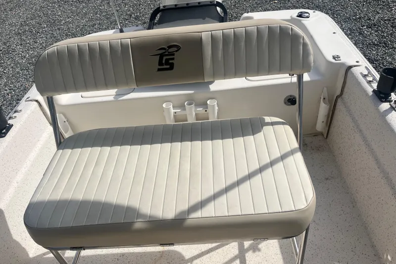Slide: The Image of 2019 Carolina Skiff 18 JVX SS boat seating with rod holders, featuring beige upholstery. - 7