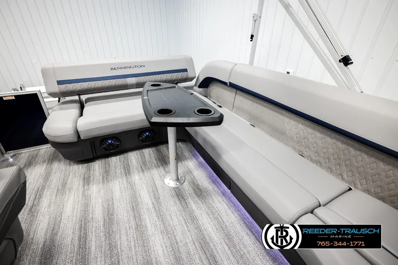 Slide: The Image of 2026 Bennington MLSF boat interior with plush seating and table, showcased by Reeder-Trausch Marine. - 27