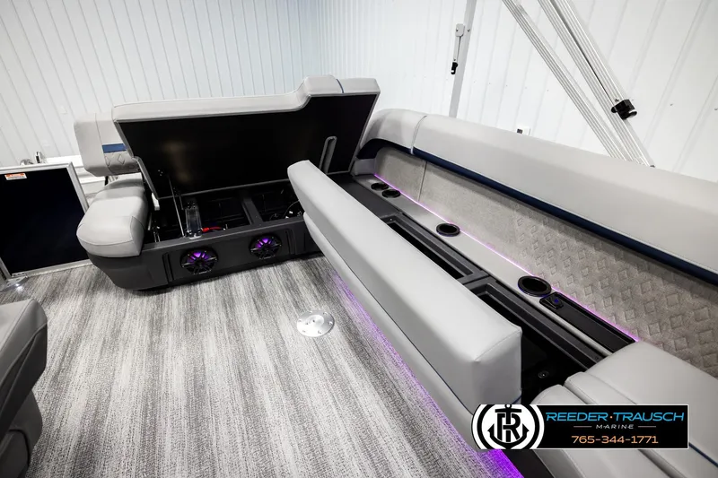 Slide: The Image of 2026 Bennington MLSF boat interior with open storage, cup holders, and ambient lighting. - 28