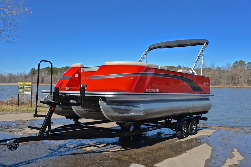 Slide: The Image of 2023 Silver Wave 2210 SW5 RLP pontoon boat on trailer by a lake. - 10