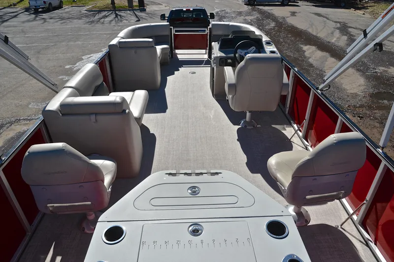 Slide: The Image of 2023 Silver Wave 2210 SW5 RLP pontoon boat interior with beige seating and red accents. - 18
