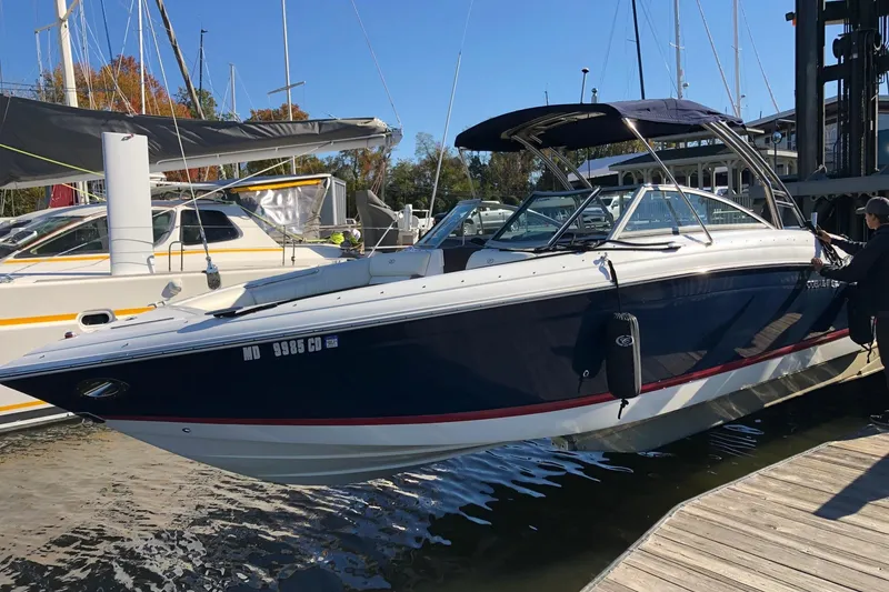 Slide: The Image of 2012 Cobalt 276 boat docked at marina with blue and white exterior. - 7