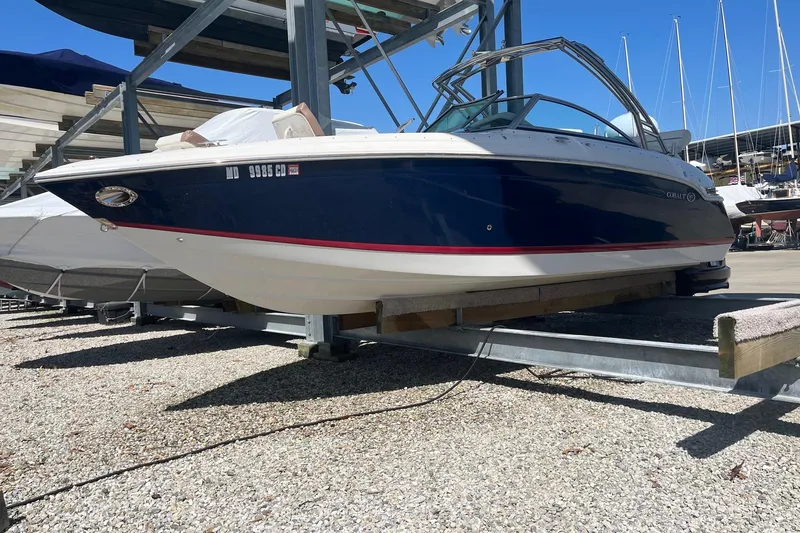 Slide: The Image of 2012 Cobalt 276 boat on trailer in marina, blue and white design. - 8