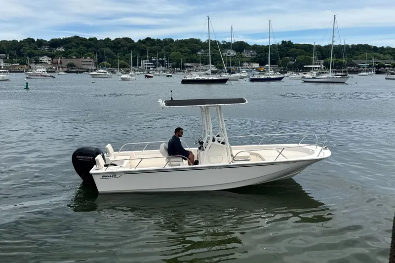 Slide: The Image of A 2026 Boston Whaler 190 Montauk on calm water with several boats in the background. - 0