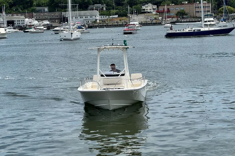 Slide: The Image of A 2026 Boston Whaler 190 Montauk cruising in a calm harbor with several boats in the background. - 2