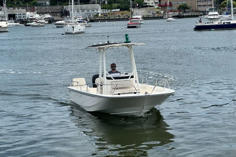 Slide: The Image of A 2026 Boston Whaler 190 Montauk on calm water with several boats in the background. - 26