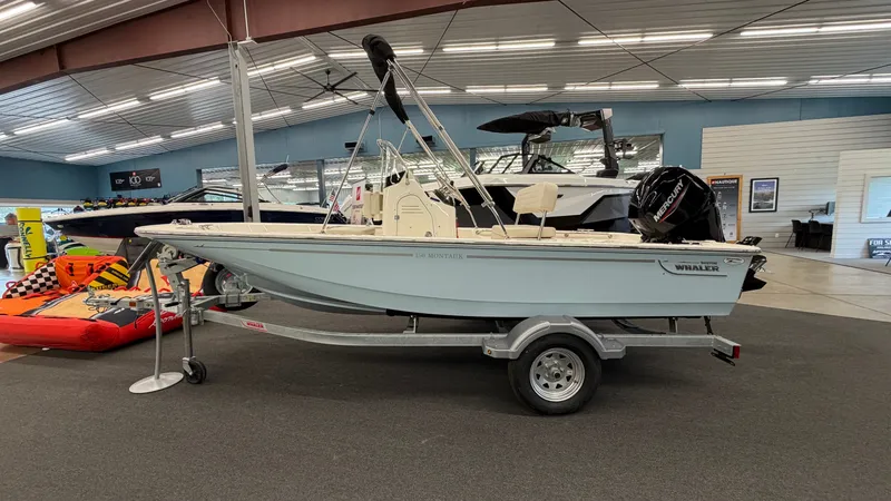 Slide: The Image of Boston Whaler 150 Montauk 2026 on a trailer in a showroom. - 0