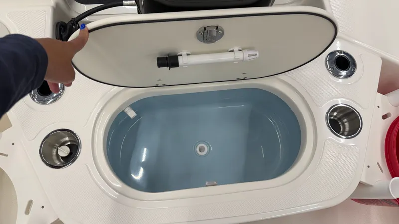 Slide: The Image of An open storage compartment on a Boston Whaler 150 Montauk boat, featuring a blue interior. - 14