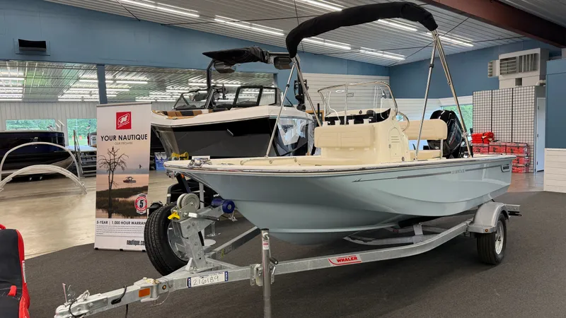 Slide: The Image of A 2026 Boston Whaler 150 Montauk on a trailer in a showroom. - 2