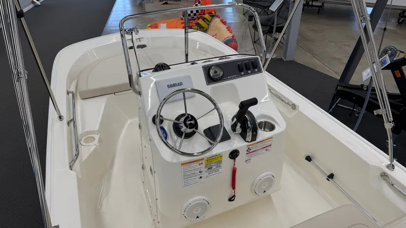 Slide: The Image of The image shows the cockpit of a Boston Whaler 150 Montauk boat with a steering console and wheel. - 21