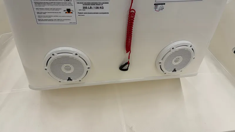 Slide: The Image of Two white speakers are mounted in a boat console, with a red cord in between. - 22