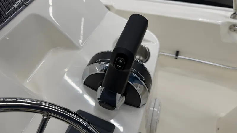 Slide: The Image of Close-up of the throttle lever and steering wheel on a Boston Whaler 150 Montauk boat. - 27