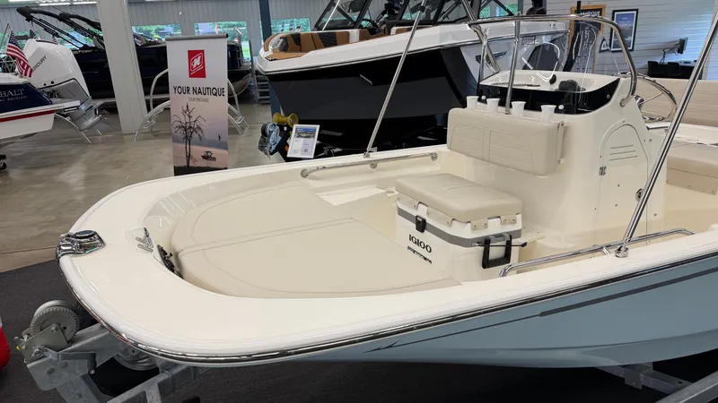 Slide: The Image of A 2026 Boston Whaler 150 Montauk is displayed in a showroom. It features a clean, white deck. - 4
