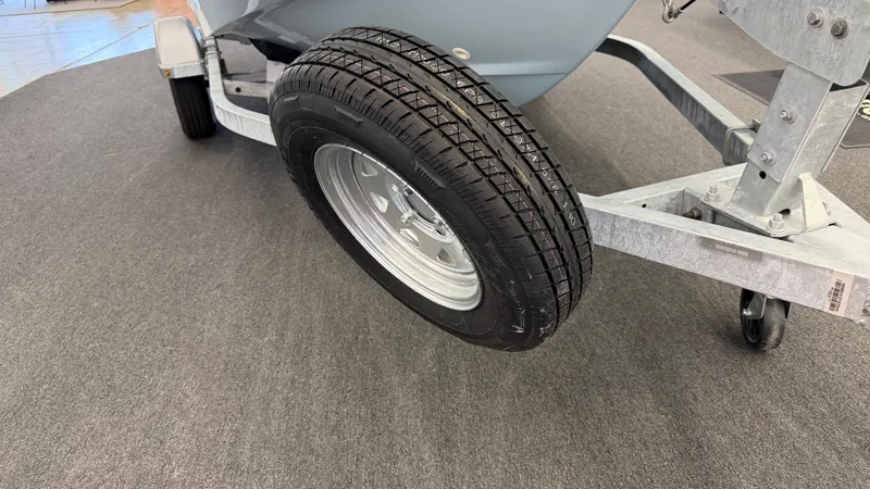 Slide: The Image of Close-up of a boat trailer with a sturdy tire on gray carpeted flooring. - 47