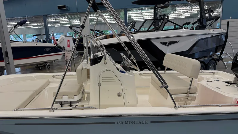 Slide: The Image of Boston Whaler 150 Montauk 2026 in a showroom, featuring sleek lines and modern equipment. - 5