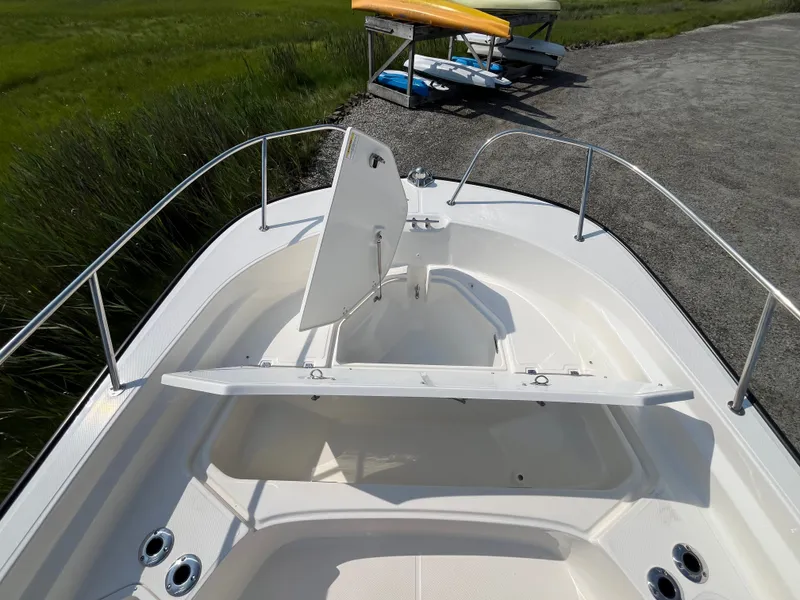 Slide: The Image of The image shows the bow deck of a Boston Whaler 210 Montauk with an open storage hatch. - 13