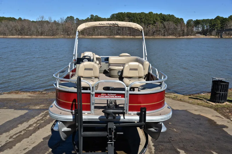 Slide: The Image of 2024 Sun Tracker Bass Buggy 18 DLX pontoon boat by a serene lake. - 17