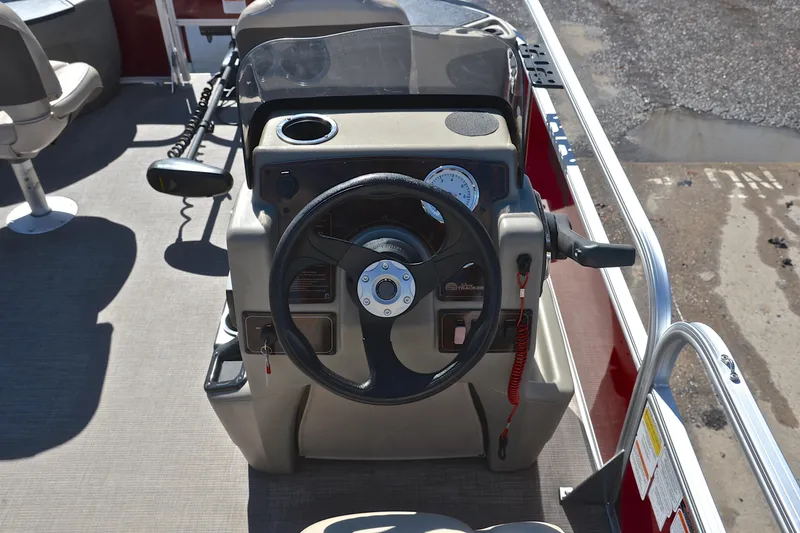 Slide: The Image of 2024 Sun Tracker Bass Buggy 18 DLX steering console with controls and gauges. - 25