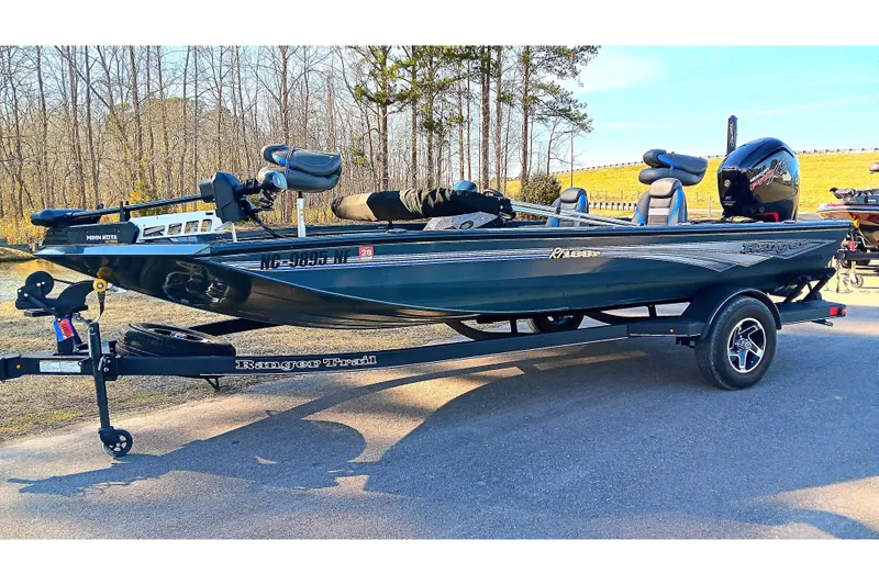 Slide: The Image of 2025 Ranger RT188P fishing boat on trailer, parked outdoors, side view. - 2