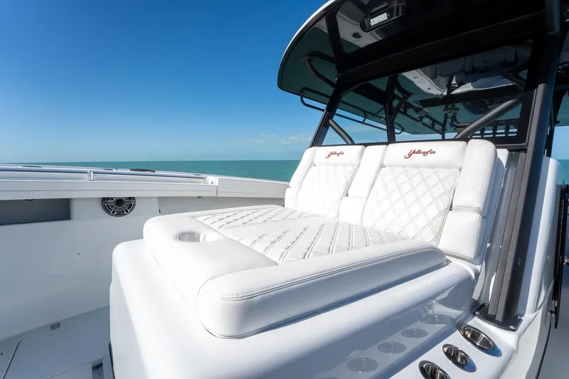 Slide: The Image of 2024 Yellowfin 42 Offshore boat with luxurious white seating and ocean backdrop. - 18