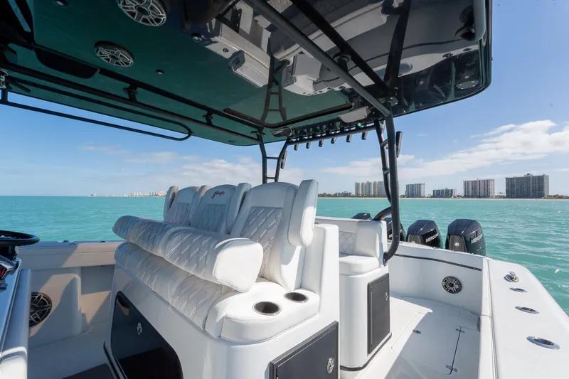 Slide: The Image of 2024 Yellowfin 42 Offshore boat interior with luxurious seating, ocean view, and city skyline. - 19