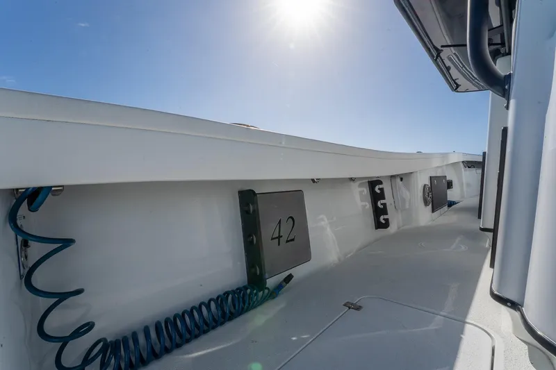 Slide: The Image of 2024 Yellowfin 42 Offshore boat deck under bright sun, showcasing sleek design. - 33