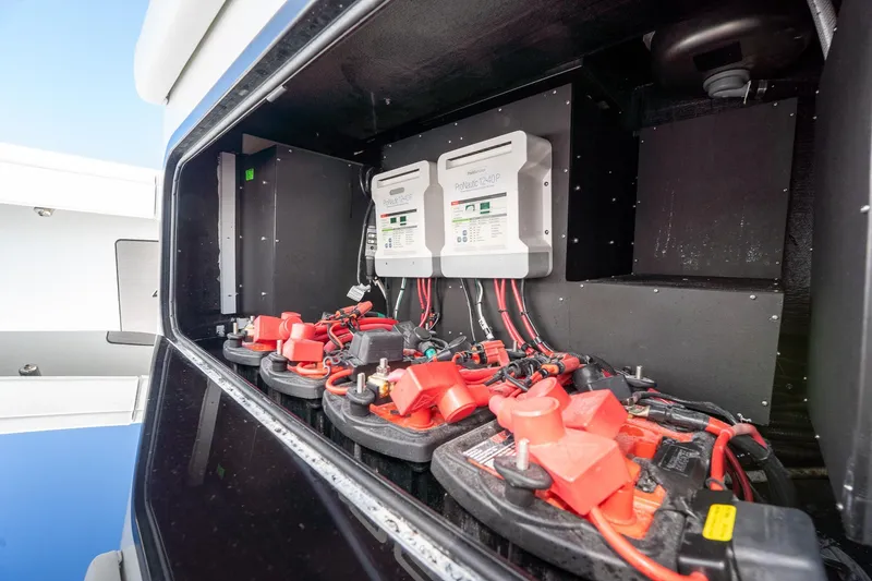 Slide: The Image of 2024 Yellowfin 42 Offshore boat battery compartment with wiring and chargers. - 39