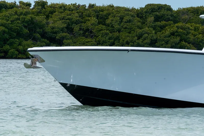 Slide: The Image of 2024 Yellowfin 42 Offshore boat bow in calm water, lush greenery background. - 5