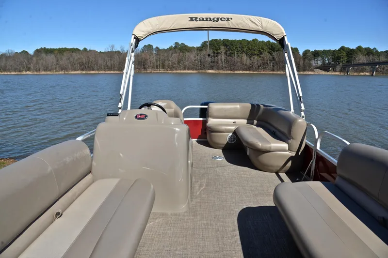Slide: The Image of 2021 Ranger 180 Reata boat on a lake, featuring spacious seating and canopy. - 20