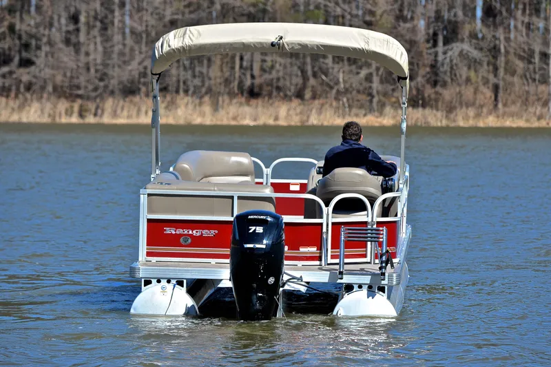 Slide: The Image of 2021 Ranger 180 Reata pontoon boat on a lake, rear view with outboard motor. - 7