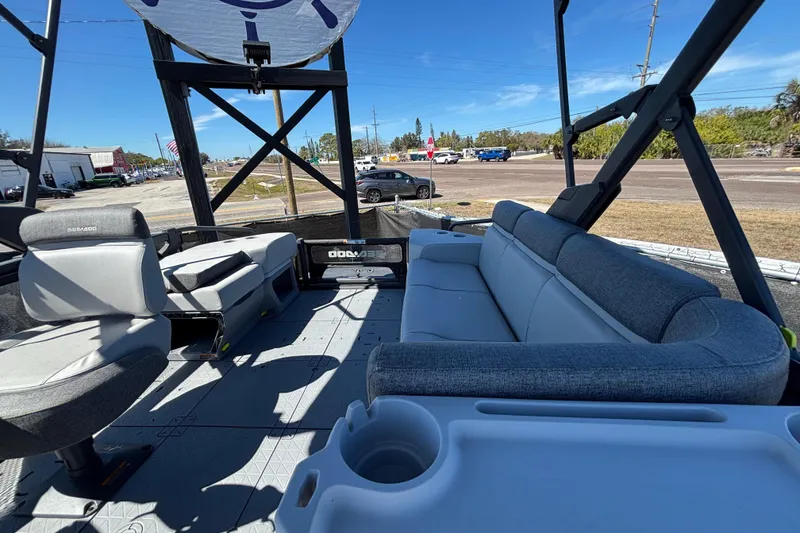 Slide: The Image of 2023 Sea-Doo Switch Cruise 21 interior with seating and cup holders, parked outdoors. - 18