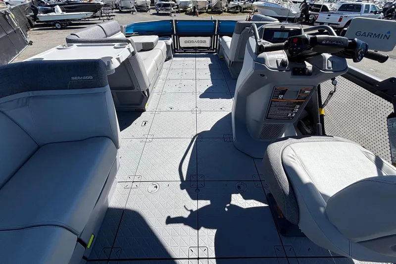 Slide: The Image of 2023 Sea-Doo Switch Cruise 21 interior with seating and control console, docked among boats. - 28