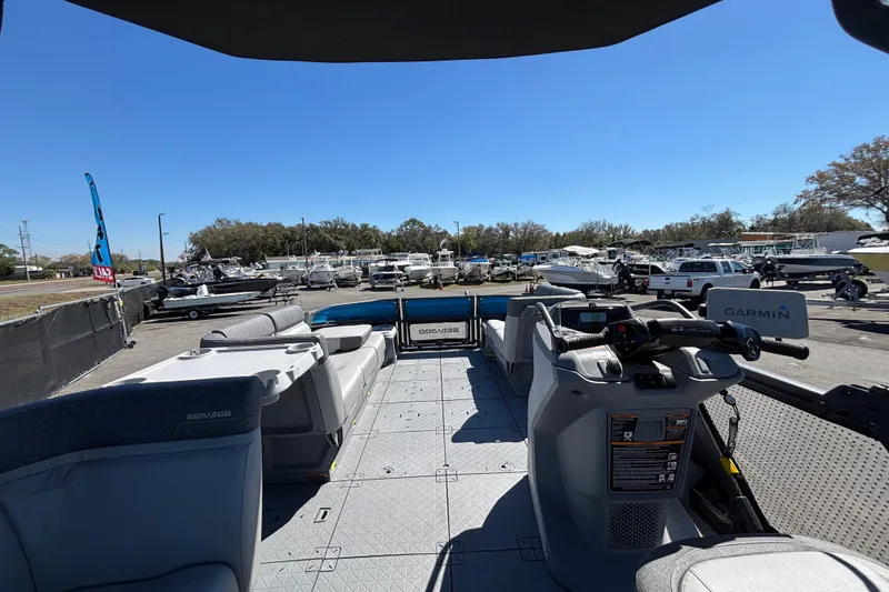 Slide: The Image of 2023 Sea-Doo Switch Cruise 21 boat interior with seating and control panel, parked outdoors. - 29