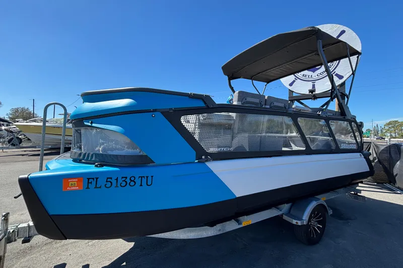 Slide: The Image of 2023 Sea-Doo Switch Cruise 21 pontoon boat, rear view, parked outdoors under clear blue sky. - 3
