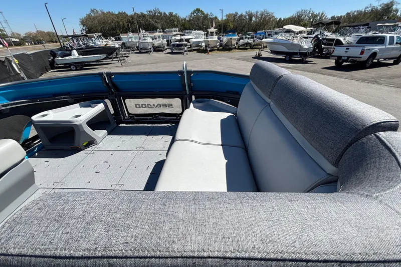 Slide: The Image of 2023 Sea-Doo Switch Cruise 21 interior with gray seating and cup holders, docked among boats. - 45