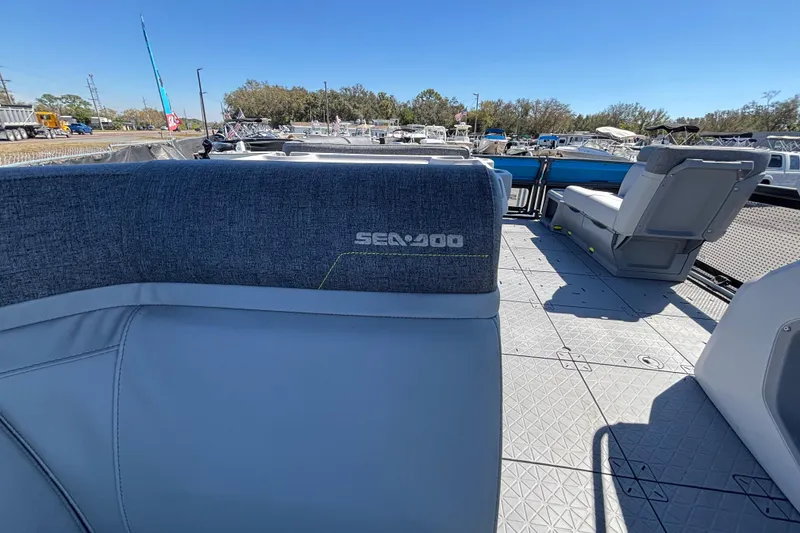 Slide: The Image of 2023 Sea-Doo Switch Cruise 21 interior with seating and cup holders, docked at a marina. - 47