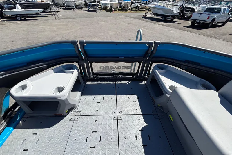 Slide: The Image of 2023 Sea-Doo Switch Cruise 21 interior with seating and storage, docked among other boats. - 48
