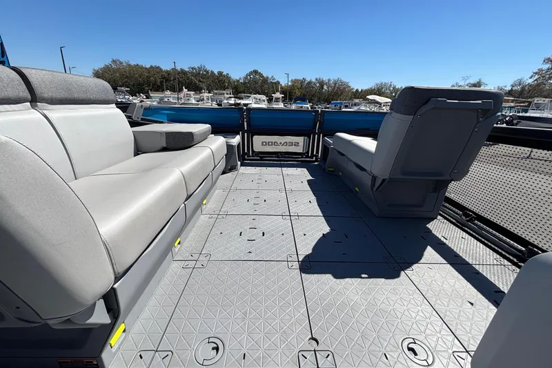 Slide: The Image of 2023 Sea-Doo Switch Cruise 21 interior with seating and cup holders, parked in a marina. - 49