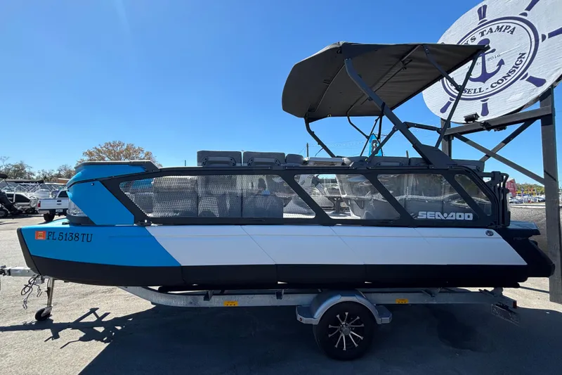 Slide: The Image of 2023 Sea-Doo Switch Cruise 21 boat on trailer, blue and white design, outdoor display. - 7