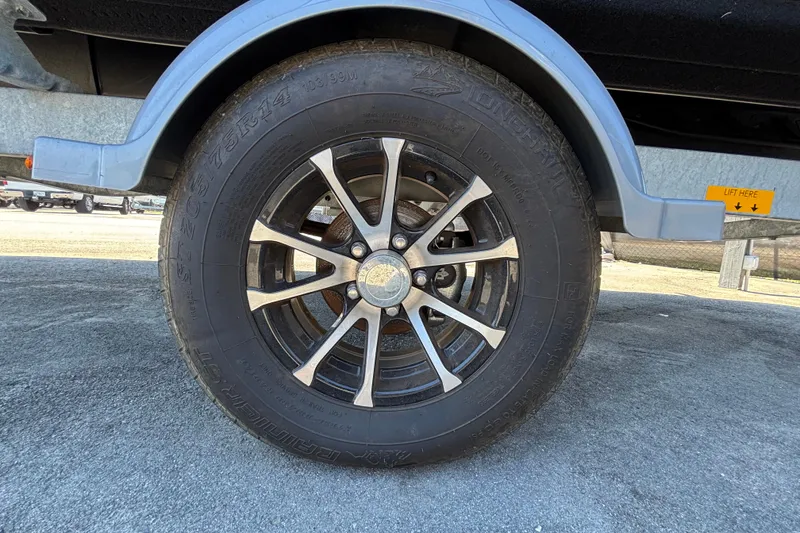 Slide: The Image of Close-up of a 2023 Sea-Doo Switch Cruise 21 trailer wheel on pavement. - 93