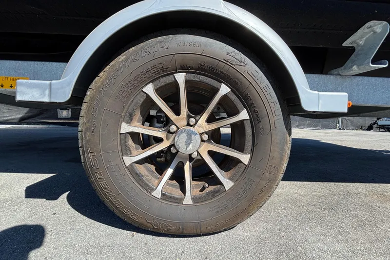 Slide: The Image of Trailer wheel of 2023 Sea-Doo Switch Cruise 21, parked on pavement. - 94