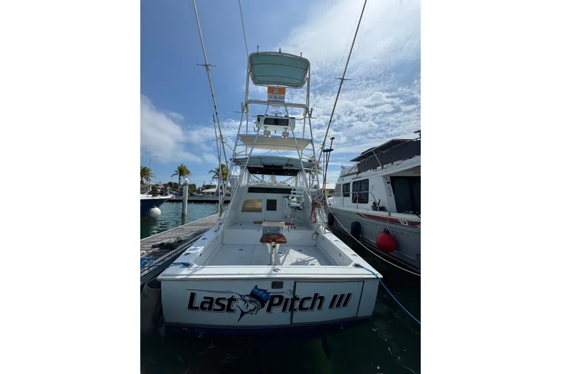 Slide: The Image of 1963 Bertram 31 Sportfisher boat docked, featuring "Last Pitch III" name on stern. - 20