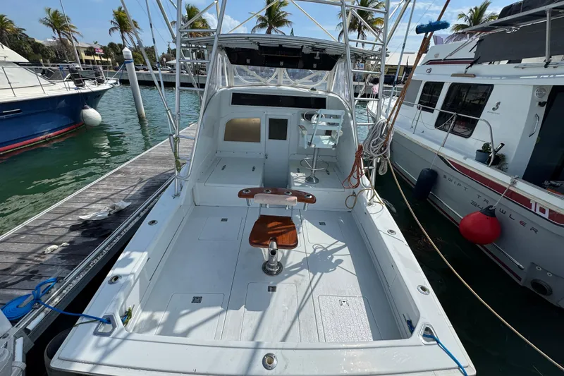 Slide: The Image of 1963 Bertram 31 Sportfisher boat docked, featuring spacious deck and fishing chair. - 22