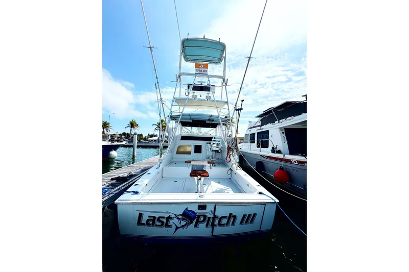 Slide: The Image of 1963 Bertram 31 Sportfisher boat docked, featuring "Last Pitch III" on the stern. - 30