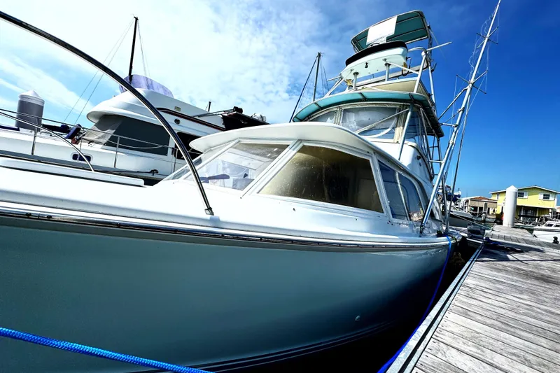 Slide: The Image of 1963 Bertram 31 Sportfisher docked at marina under clear blue sky. - 31