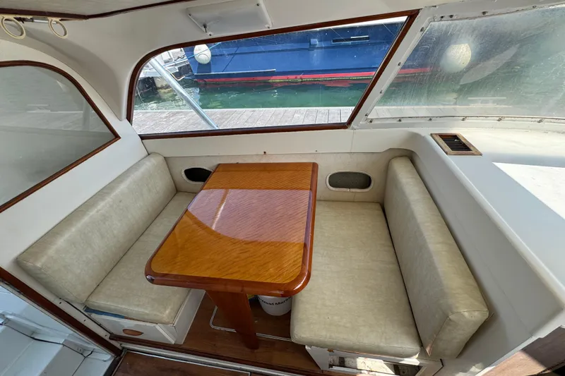 Slide: The Image of Interior of a 1963 Bertram 31 Sportfisher with a wooden table and cushioned seating. - 4