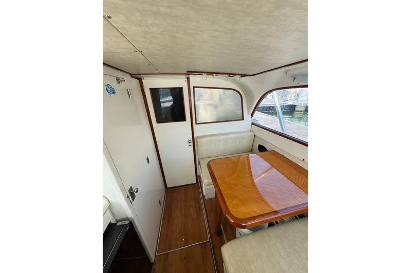 Slide: The Image of Interior of a 1963 Bertram 31 Sportfisher with wooden table and seating area. - 6