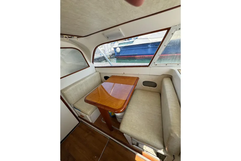 Slide: The Image of Interior of a 1963 Bertram 31 Sportfisher with a wooden table and cushioned seating. - 7