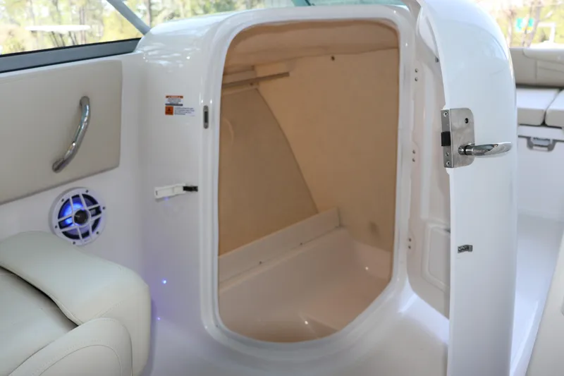 Slide: The Image of 2026 Robalo R207 Dual Console boat interior storage compartment with open door. - 15